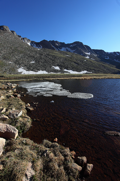Sitting at 12,830 ft, Summit Lake is still partially frozen. The lake sits in a cirque formed by the peaks of Mt. Evans and Mt...