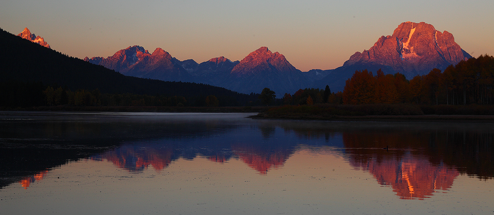 The first rays of light hit the top of these mighty peaks. Mt Moran can be seen on the right. &nbsp;The Grand is the mountain...
